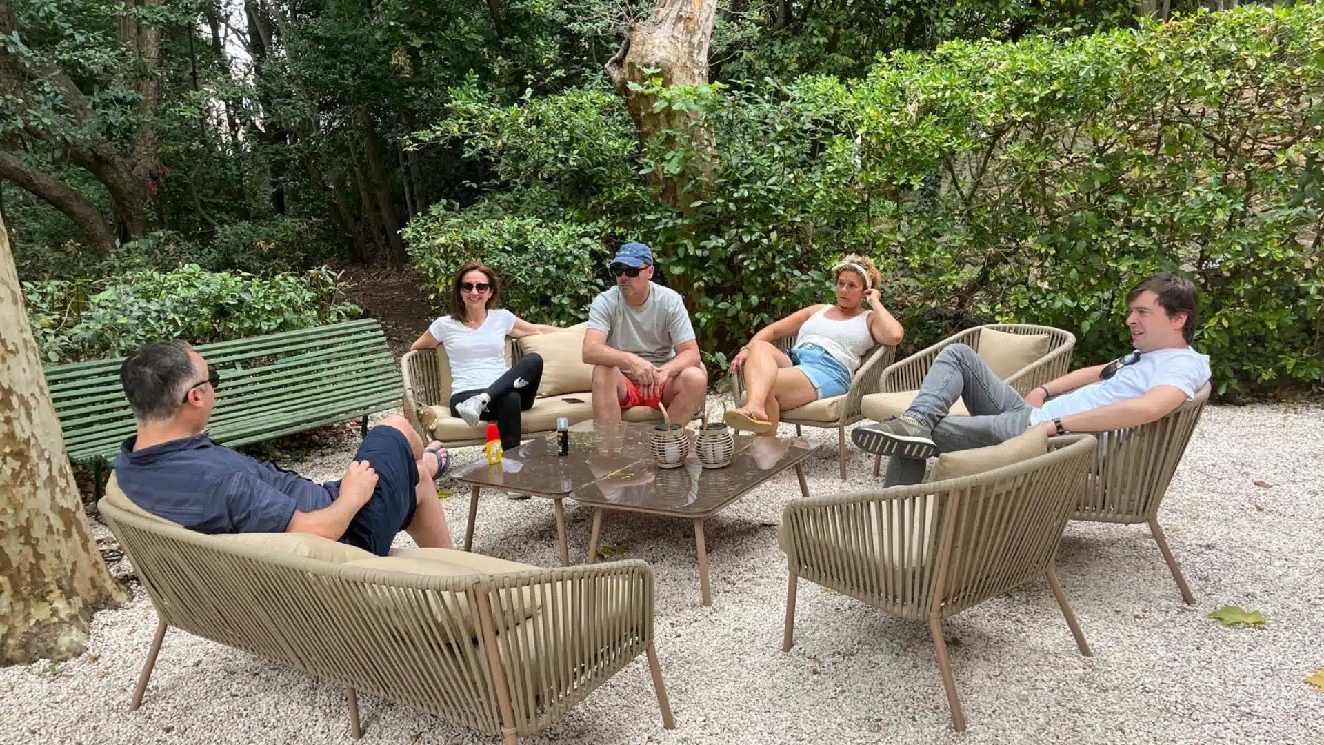 Invités profitant d’un moment convivial sur des salons de jardin lors d’un anniversaire intimiste organisé avec des tentes dans une propriété familiale.