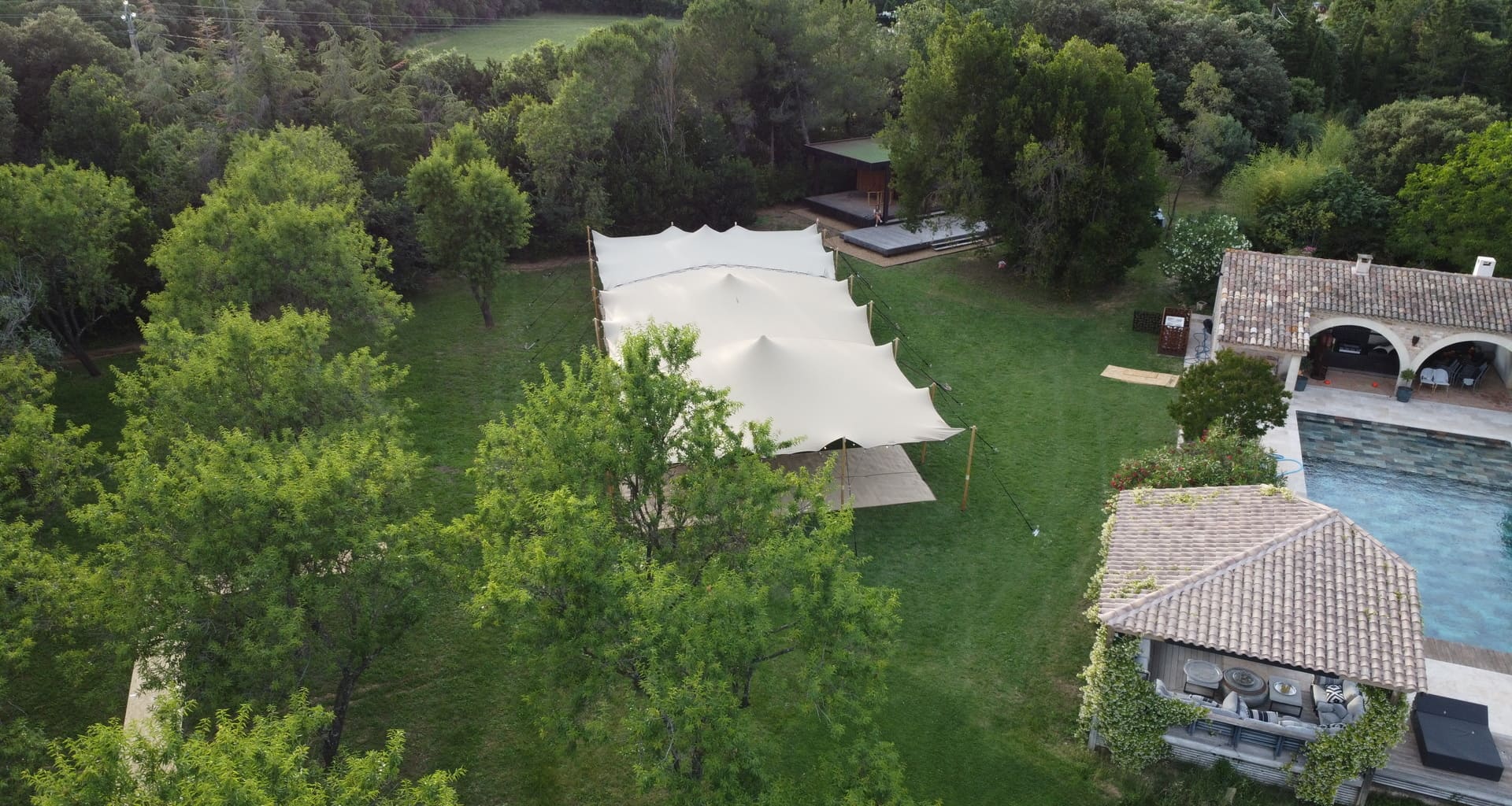 Installation d'une tente nomade pour un mariage à domicile au bord d'une piscine.